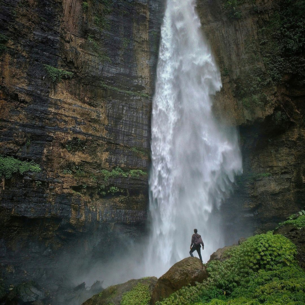 Man standing at waterfall